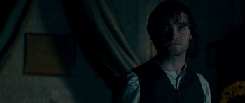 Movie still from “The Woman in Black” (2012), directed by James Watkins – A man standing in a dark room looking at the camera; Close Up shot, Over the shoulder angle
