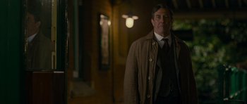 Movie still from “The Woman in Black” (2012), directed by James Watkins – A man wearing a brown coat and a tie; Medium shot, Over the shoulder angle