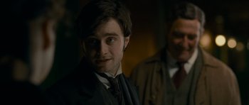 Movie still from “The Woman in Black” (2012), directed by James Watkins – A person wearing a suit and tie; Close Up shot, Over the shoulder angle