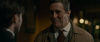 Movie still from “The Woman in Black” (2012), directed by James Watkins – An older man wearing a jacket and a tie; Close Up shot, Over the shoulder angle
