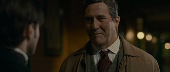 Movie still from “The Woman in Black” (2012), directed by James Watkins – An older man wearing a jacket and tie; Close Up shot, Low angle