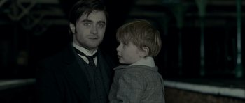 Movie still from “The Woman in Black” (2012), directed by James Watkins – A man and a boy are standing next to each other; Close Up shot, Over the shoulder angle