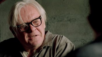 Movie still from “The World's Fastest Indian” (2005), directed by Roger Donaldson – An older man wearing glasses looking at the camera; Close Up shot, Over the shoulder angle