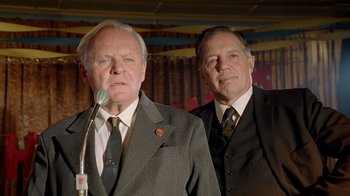 Movie still from “The World's Fastest Indian” (2005), directed by Roger Donaldson – Two men in suits and ties standing next to each other; Close Up shot, Low angle
