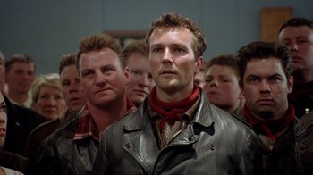 Movie still from “The World's Fastest Indian” (2005), directed by Roger Donaldson – A group of men standing next to each other in a room; Close Up shot, Low angle