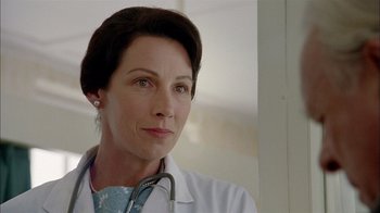 Movie still from “The World's Fastest Indian” (2005), directed by Roger Donaldson – A woman in a white lab coat with a stethoscope around her neck; Close Up shot, Low angle