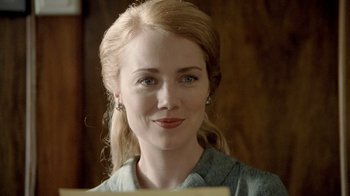 Movie still from “The World's Fastest Indian” (2005), directed by Roger Donaldson – A beautiful woman with blonde hair and blue eyes looking at the camera; Close Up shot, Over the shoulder angle