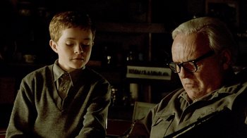 Movie still from “The World's Fastest Indian” (2005), directed by Roger Donaldson – An older man and a young boy are looking at a book; Medium shot, Low angle