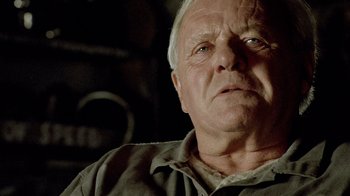 Movie still from “The World's Fastest Indian” (2005), directed by Roger Donaldson – An older man with a gray beard and a green shirt; Close Up shot, Over the shoulder angle