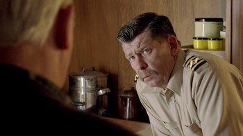 Movie still from “The World's Fastest Indian” (2005), directed by Roger Donaldson – A person with a beard and mustache; Close Up shot, Over the shoulder angle