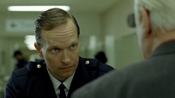 Movie still from “The World's Fastest Indian” (2005), directed by Roger Donaldson – A person wearing a uniform; Close Up shot, Over the shoulder angle