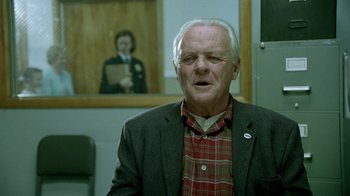 Movie still from “The World's Fastest Indian” (2005), directed by Roger Donaldson – An older man wearing a plaid shirt and a jacket; Close Up shot, Over the shoulder angle