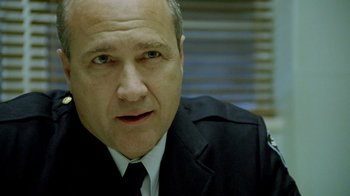 Movie still from “The World's Fastest Indian” (2005), directed by Roger Donaldson – A person wearing a police uniform; Close Up shot, Over the shoulder angle