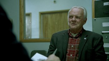 Movie still from “The World's Fastest Indian” (2005), directed by Roger Donaldson – An older man wearing a red plaid shirt and a black jacket; Close Up shot, Over the shoulder angle