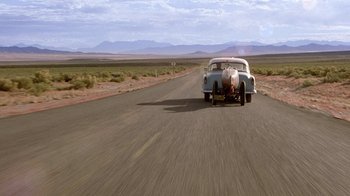 Movie still from “The World's Fastest Indian” (2005), directed by Roger Donaldson – An old car driving down the middle of the road; Extreme Wide shot, Low angle