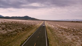 Movie still from “The World's Fastest Indian” (2005), directed by Roger Donaldson – A car driving down the middle of an empty road; Extreme Wide shot, High angle