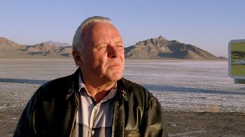 Movie still from “The World's Fastest Indian” (2005), directed by Roger Donaldson – An older man wearing a leather jacket looks off into the distance; Close Up shot, Low angle