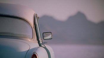Movie still from “The World's Fastest Indian” (2005), directed by Roger Donaldson – The side view mirror of an antique car; Wide shot, Low angle