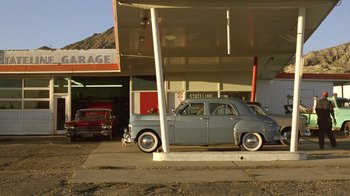Movie still from “The World's Fastest Indian” (2005), directed by Roger Donaldson – An old car parked in front of a gas station; Extreme Wide shot, Low angle