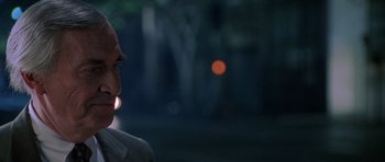 Movie still from “The X Files” (1998), directed by Rob Bowman – A man with a light in his mouth is in the dark; Close Up shot, Over the shoulder angle