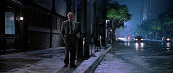 Movie still from “The X Files” (1998), directed by Rob Bowman – A man standing on the side of the street at night; Wide shot, Low angle