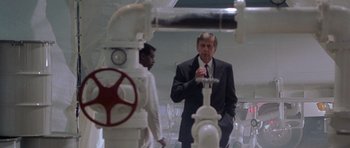 Movie still from “The X Files” (1998), directed by Rob Bowman – A man standing next to a fire hydrant; Medium shot, Low angle