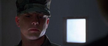Movie still from “The X Files” (1998), directed by Rob Bowman – A man in a military uniform looking at the camera; Close Up shot, Low angle
