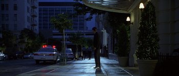 Movie still from “The X Files” (1998), directed by Rob Bowman – A man standing on the sidewalk at night; Wide shot, Low angle