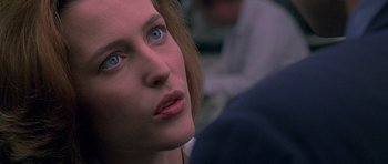 Movie still from “The X Files” (1998), directed by Rob Bowman – A person with blue eyes; Close Up shot, Over the shoulder angle