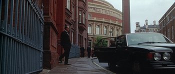 Movie still from “The X Files” (1998), directed by Rob Bowman – A man walking down a sidewalk next to a building; Extreme Wide shot, Low angle