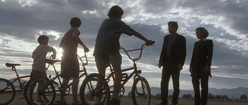 Movie still from “The X Files” (1998), directed by Rob Bowman – A group of people standing next to a bicycle; Wide shot, Low angle