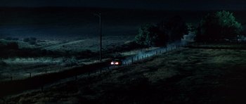 Movie still from “The X Files” (1998), directed by Rob Bowman – A car driving down a road at night; Extreme Wide shot, High angle