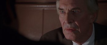 Movie still from “The X Files” (1998), directed by Rob Bowman – An older man in a brown suit and white shirt; Close Up shot, Over the shoulder angle