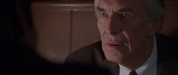 Movie still from “The X Files” (1998), directed by Rob Bowman – An older man in a suit looking at a computer screen; Close Up shot, Over the shoulder angle