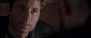 Movie still from “The X Files” (1998), directed by Rob Bowman – A person wearing a leather jacket; Close Up shot, Over the shoulder angle