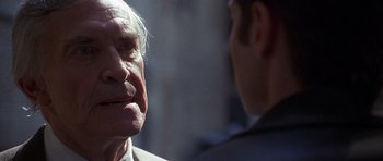 Movie still from “The X Files” (1998), directed by Rob Bowman – An older man and a younger man are talking together; Close Up shot, Over the shoulder angle