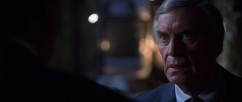 Movie still from “The X Files” (1998), directed by Rob Bowman – An older man is looking at the camera; Close Up shot, Over the shoulder angle