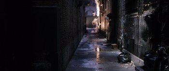 Movie still from “The X Files” (1998), directed by Rob Bowman – An alleyway in a dark city with smoke billowing out of the windows; Extreme Wide shot, High angle