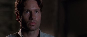 Movie still from “The X Files” (1998), directed by Rob Bowman – A person looking at the camera; Close Up shot, Low angle