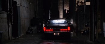 Movie still from “The X Files” (1998), directed by Rob Bowman – The back end of a car in a dark garage; Wide shot, Low angle