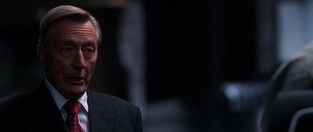 Movie still from “The X Files” (1998), directed by Rob Bowman – A person wearing a suit and tie; Close Up shot, Over the shoulder angle