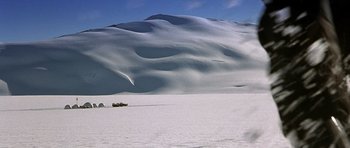Movie still from “The X Files” (1998), directed by Rob Bowman – A truck driving on a snow covered slope; Extreme Wide shot, High angle