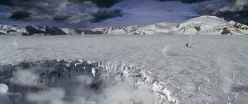 Movie still from “The X Files” (1998), directed by Rob Bowman – A view of a mountain range from a plane window; Extreme Wide shot, High angle