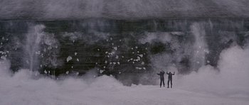 Movie still from “The X Files” (1998), directed by Rob Bowman – Two people standing in the snow near a wall of steam; Extreme Wide shot, Low angle