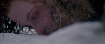 Movie still from “The X Files” (1998), directed by Rob Bowman – A woman laying down in the snow wearing a fur coat; Extreme Close Up shot, Overhead angle