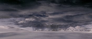 Movie still from “The X Files” (1998), directed by Rob Bowman – A dark sky over a snowy mountain range; Extreme Wide shot, High angle
