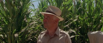 Movie still from “The X Files” (1998), directed by Rob Bowman – An older man wearing a straw hat in a field; Close Up shot, Low angle