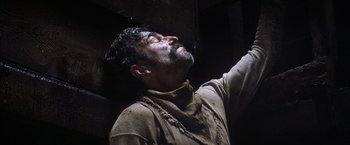 Movie still from “There Will Be Blood” (2007), directed by Paul Thomas Anderson – A man with his eyes closed and his hands up; Close Up shot, Low angle