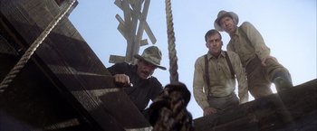 Movie still from “There Will Be Blood” (2007), directed by Paul Thomas Anderson – A group of men standing next to each other on top of a wooden structure; Medium shot, Low angle