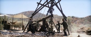 Movie still from “There Will Be Blood” (2007), directed by Paul Thomas Anderson – A group of men working on a wooden structure; Wide shot, Low angle